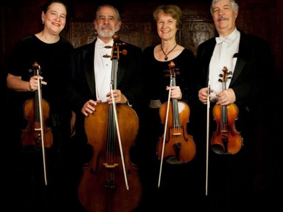 Four people are holding musical instrument.