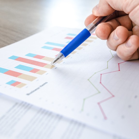 A hand with pen working on a chart
