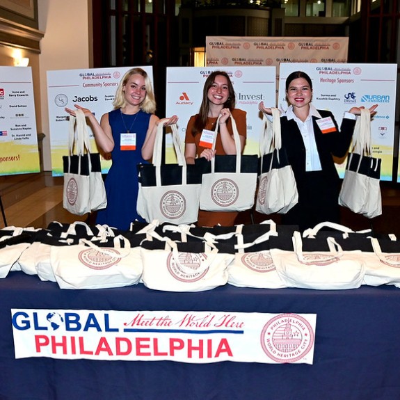 Three women holding swag bags at Global Philadelphia event