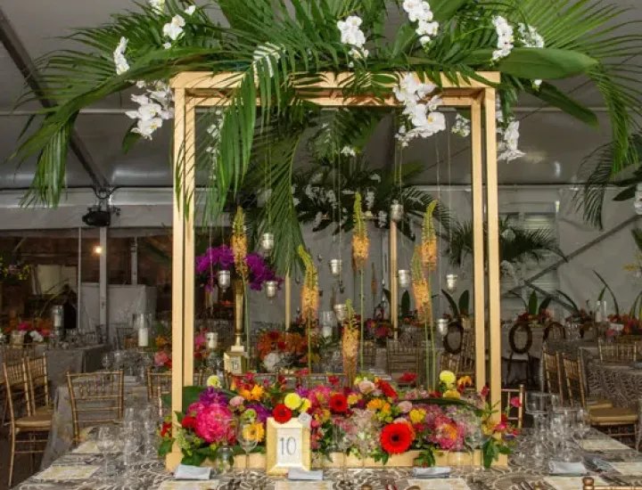 A dinning table is decorated with different flowers and leaves.