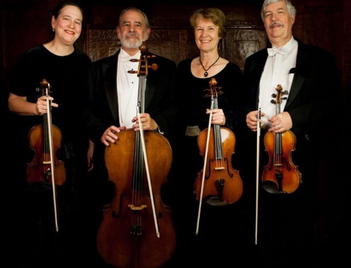 Four people are holding musical instrument.